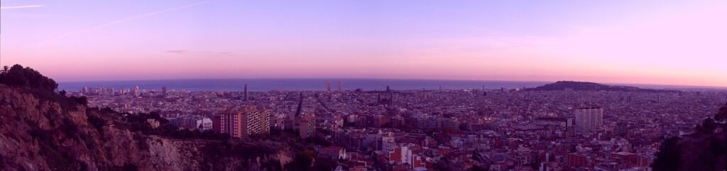Barcelona skyline at golden hour with the Sagrada Família and the Mediterranean