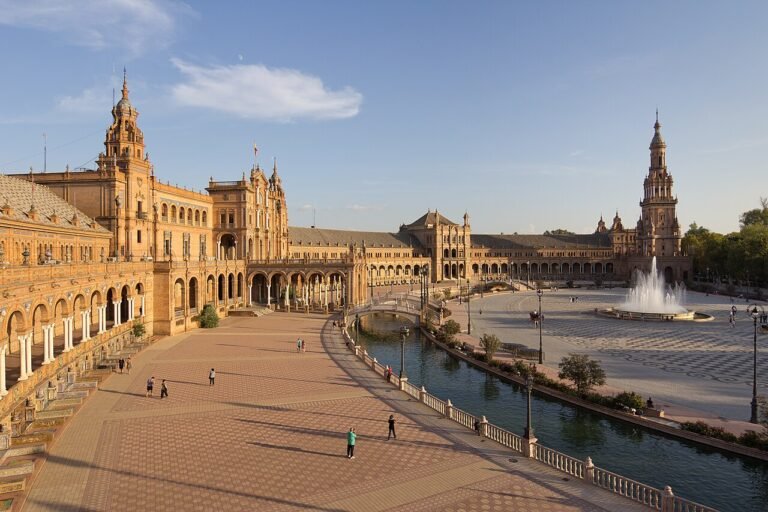 Plaza de España in Seville at golden hour with its towers, canal and tiled bridges